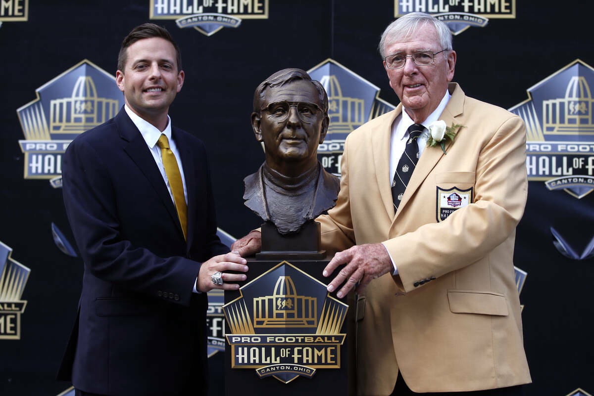 El ex colaborador de la NFL Ron Wolf, a la derecha, posa con un busto suyo y del presentador, s ...