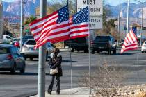 Juanesha Bivens camina por West Sahara Avenue mientras banderas estadounidenses ondean al vient ...