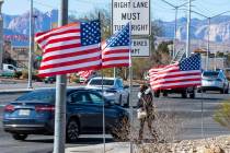 Juanesha Bivens camina por West Sahara Avenue mientras las banderas estadounidenses ondean al v ...