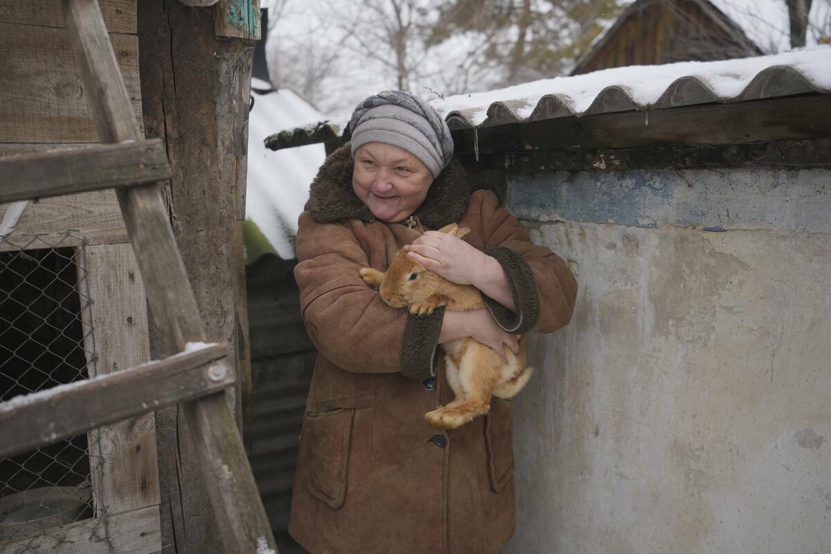 Olga, una de las 16 residentes que aún viven en un pueblo de la línea del frente, sostiene un ...