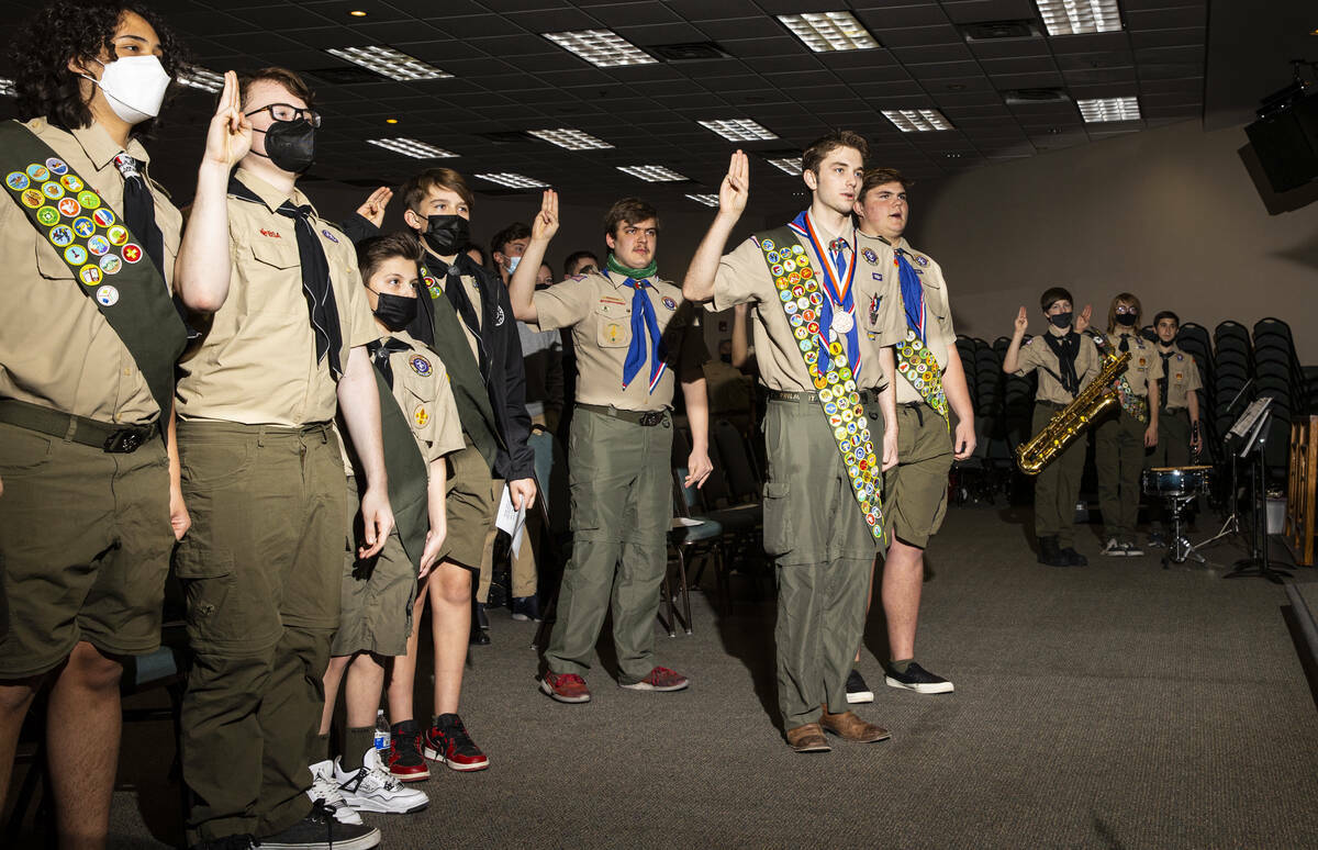 Cash Karlen, de la Tropa 912 de Boy Scouts, centro derecha, participa en el Juramento Scout ant ...
