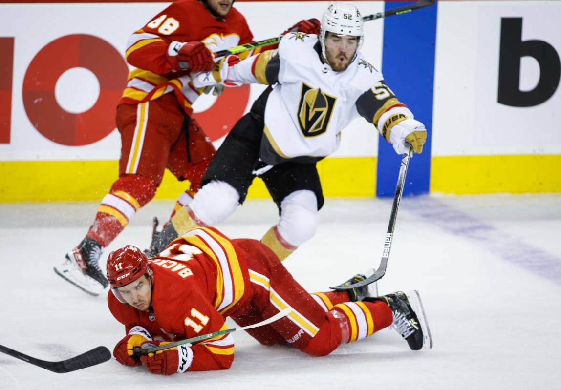 Dylan Coghlan, de los Vegas Golden Knights, a la derecha, choca con Mikael Backlund, de los Cal ...