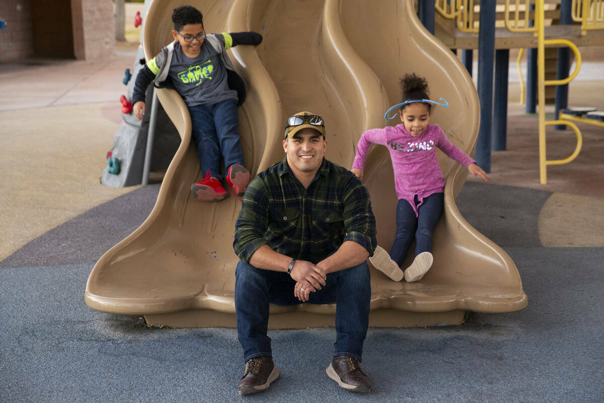 El agente de policía de North Las Vegas Nicholas Quintana posa para un retrato con sus hijos a ...