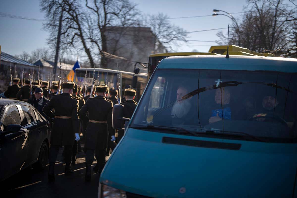Soldados de la guardia de honor pasan junto a una furgoneta que transporta sacerdotes en la ciu ...