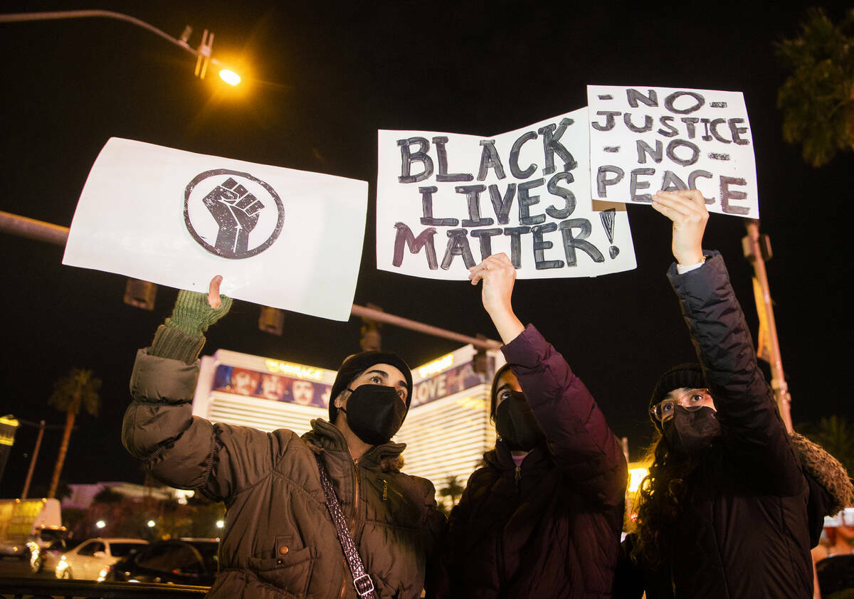 Manifestantes sostienen letreros exigiendo justicia para Isaiah Williams, de 19 años, que fue ...