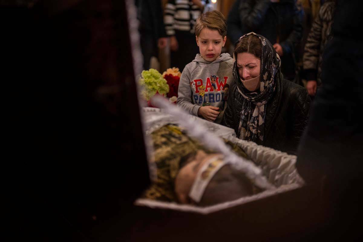 Una mujer y un niño reaccionan junto al cuerpo del capitán del ejército ucraniano Anton Sydo ...