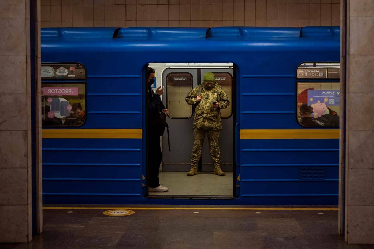 Un oficial del ejército ucraniano mira su teléfono en un tren local en Kyiv, Ucrania, el mié ...