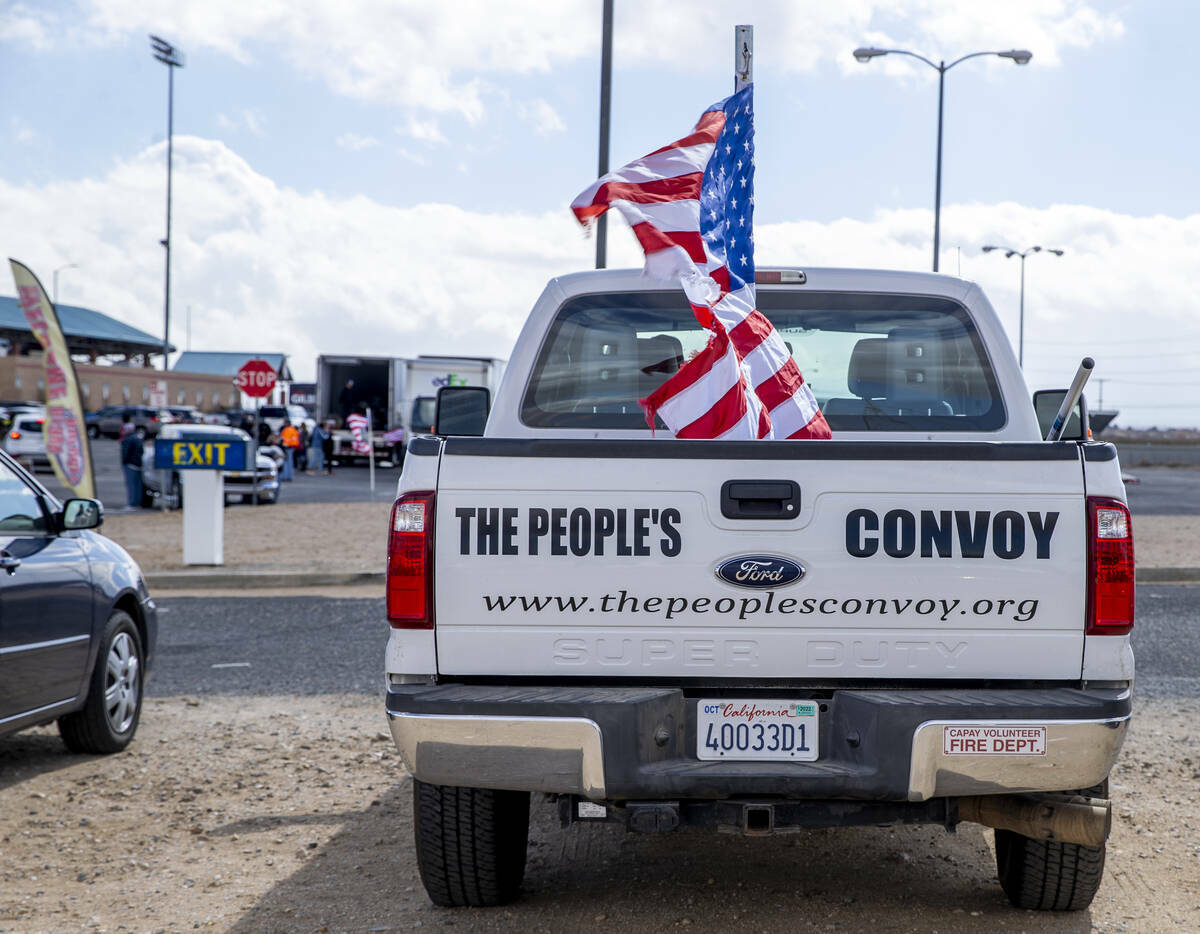 Un camión en el estacionamiento anuncia The People's Convoy mientras los asistentes comienzan ...