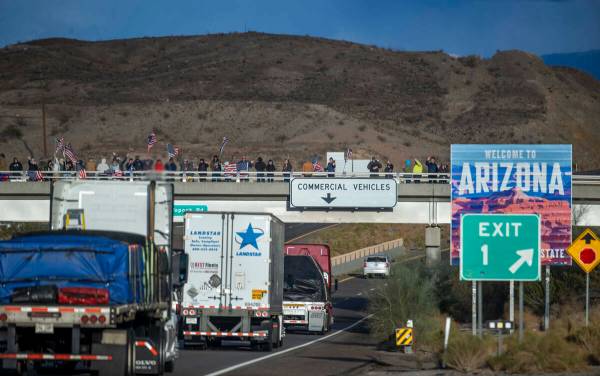 Simpatizantes se alinean en un paso elevado de la I-40 en la frontera de Arizona esperando el P ...