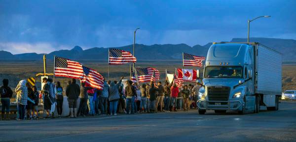 Simpatizantes se alinean en un paso elevado de la I-40 en la frontera de Arizona esperando el P ...