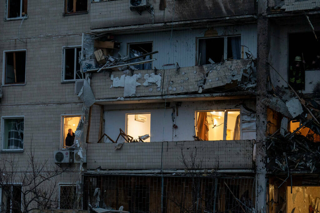 Un hombre inspecciona los daños en un edificio tras un ataque con cohetes en la ciudad de Kiev ...