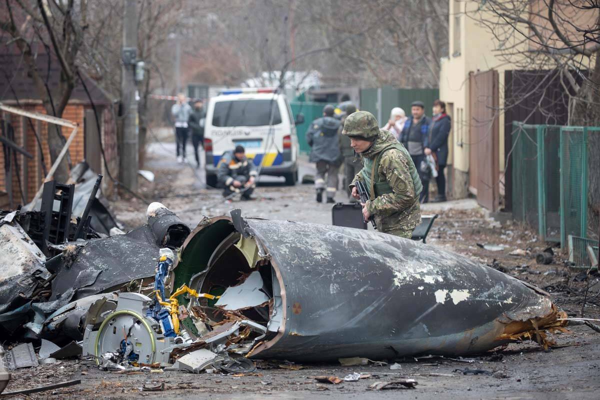 Un soldado del ejército ucraniano inspecciona fragmentos de un avión derribado en Kiev, Ucran ...