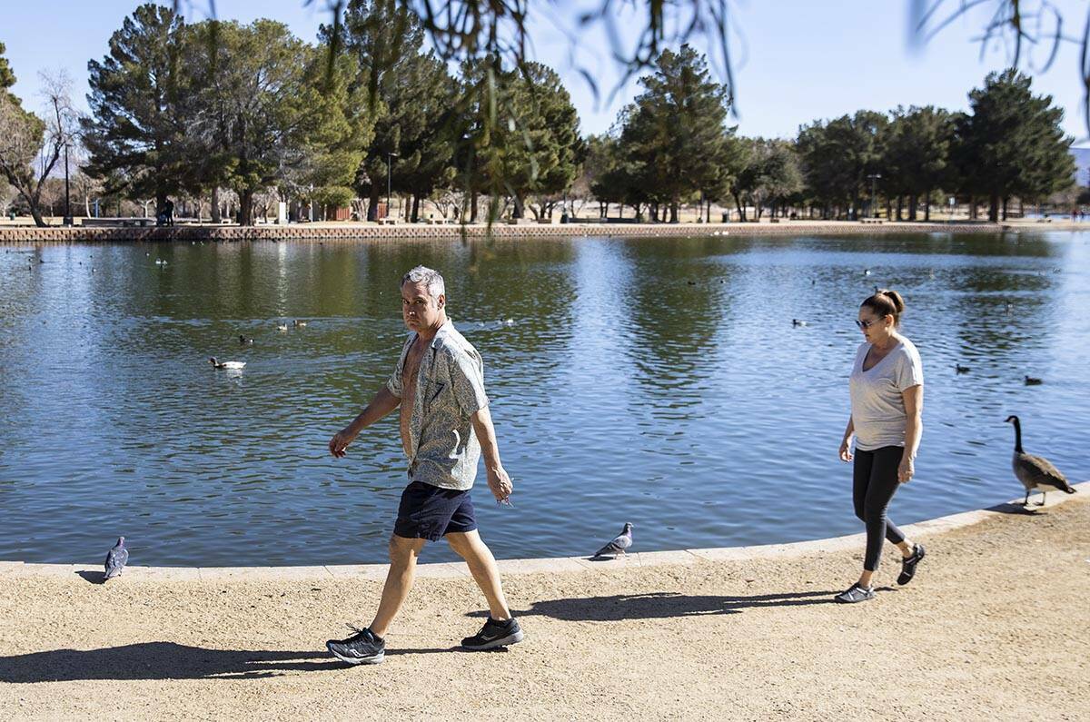 Brian Patterson y su esposa Tammy, de Las Vegas, pasean por el estanque de Sunset Park el miér ...
