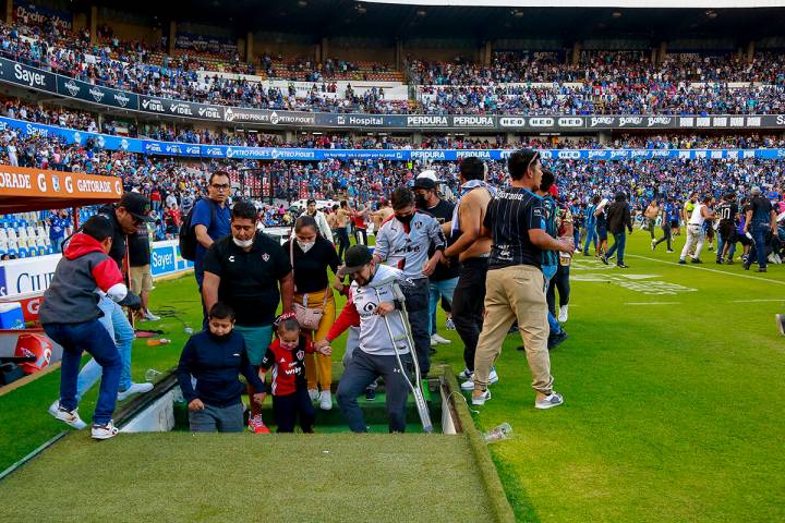 Aficionados de Querétaro y Atlas se enfrentan durante un partido de la liga mexicana de fútbo ...