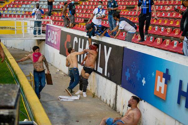 Aficionados riñen durante un partido de la liga mexicana de fútbol entre el anfitrión Queré ...