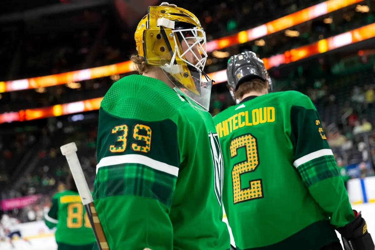 El portero de los Golden Knights Laurent Brossoit (39) y el defensa Zach Whitecloud (2) llevan ...