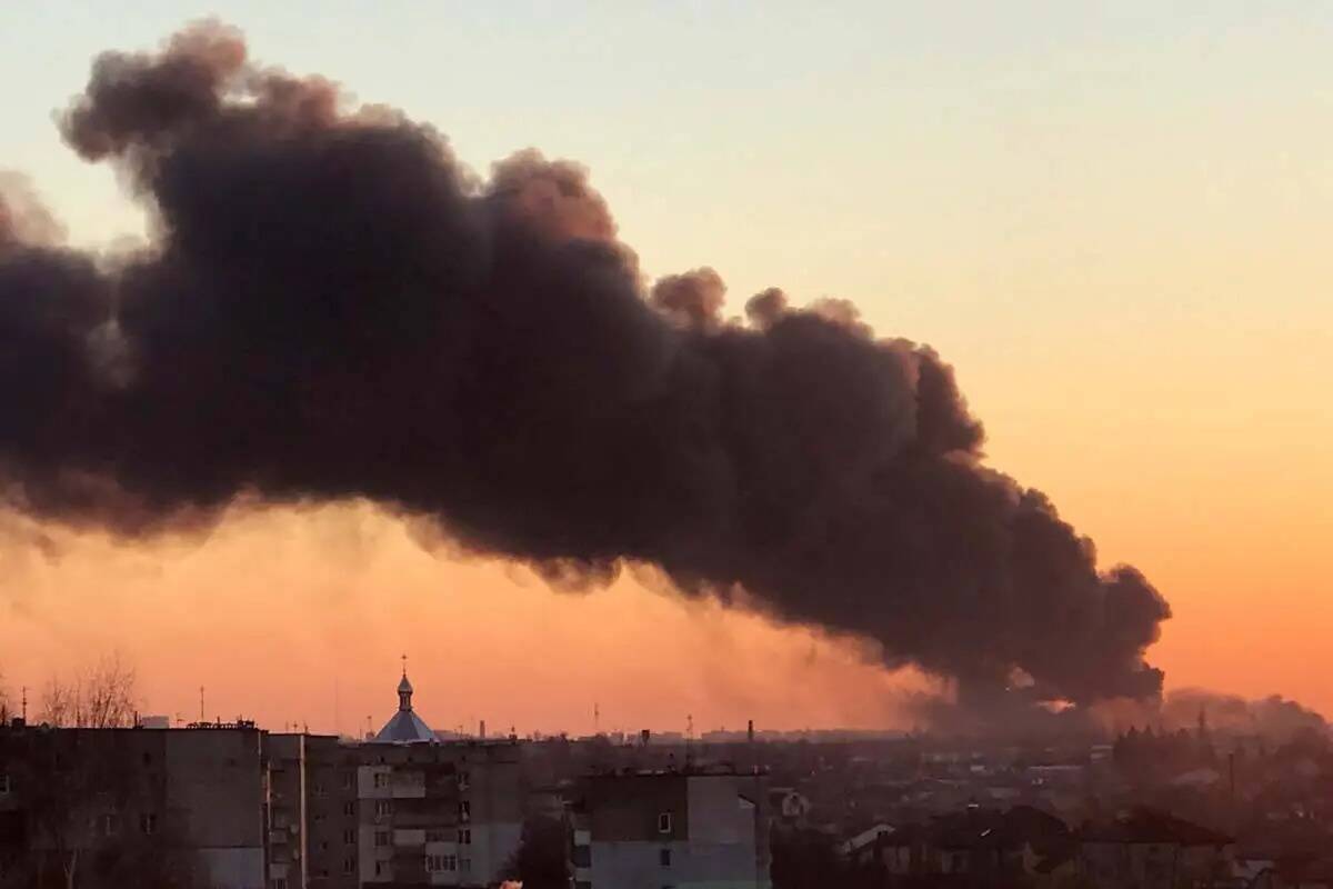 Una nube de humo se eleva tras una explosión en Lviv, al oeste de Ucrania, el viernes 18 de ma ...