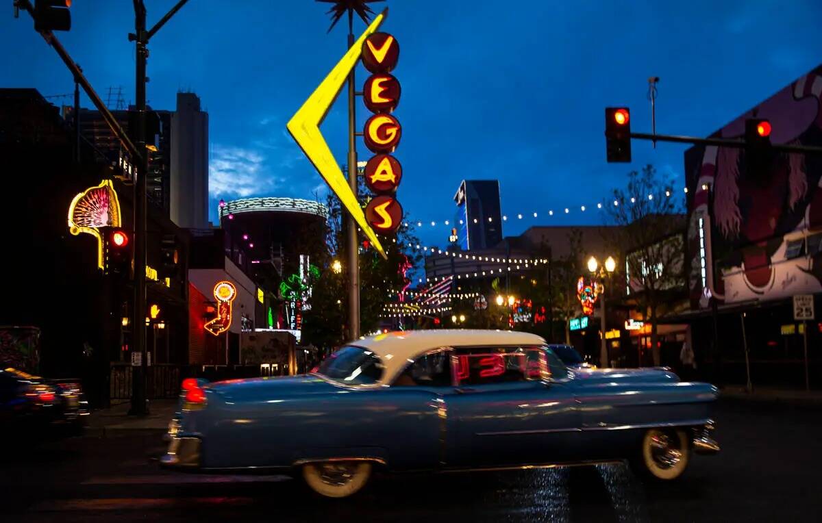 Un Cadillac Coupe DeVille de 1954 gira en Fremont Street mientras llueve el lunes 28 de marzo d ...
