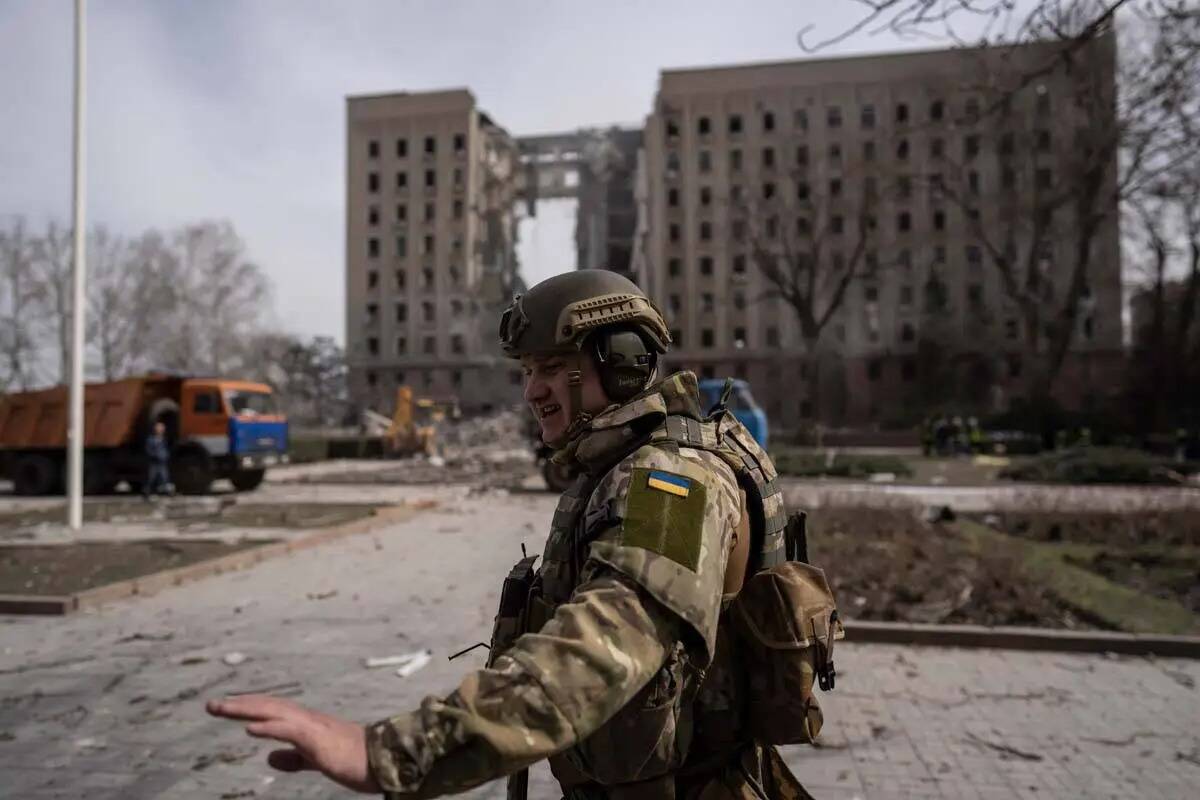 Un soldado ucraniano asegura la zona junto a la sede del gobierno regional de Mykolaiv, Ucrania ...