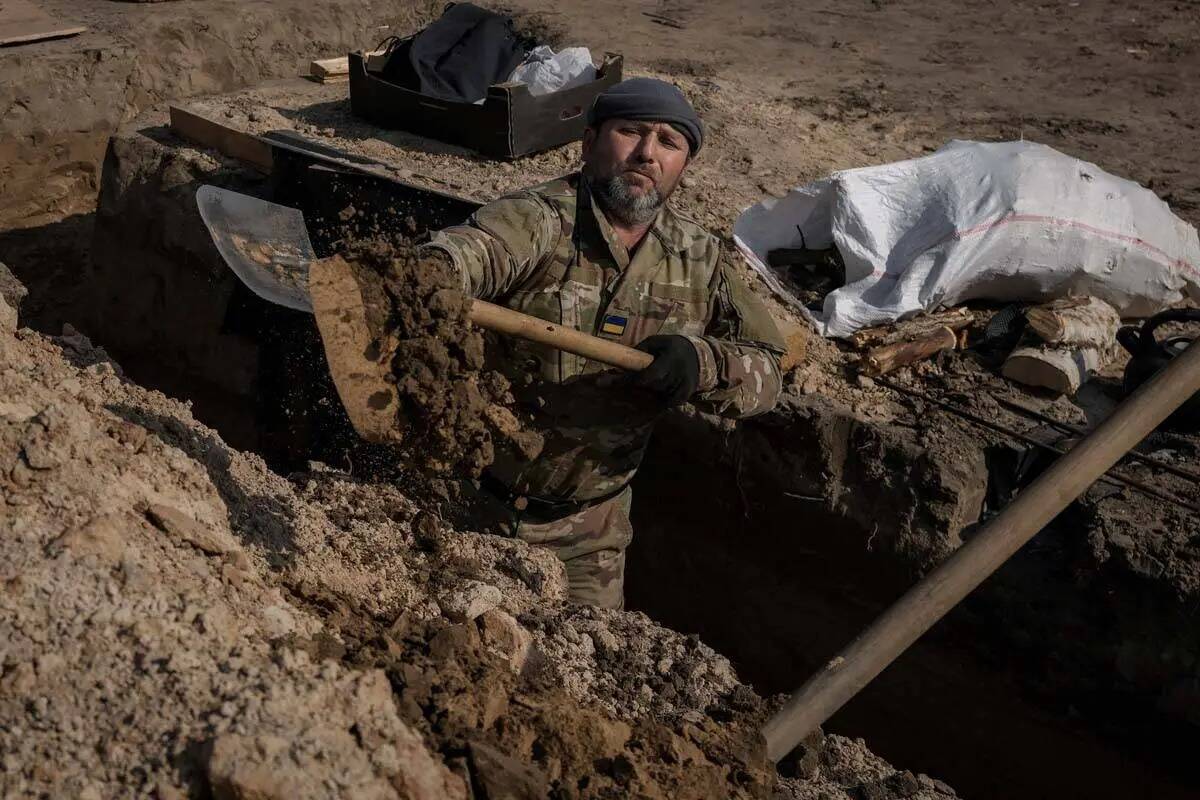 Un militar ucraniano cava una trinchera en una posición al norte de la capital, Kiev, Ucrania, ...