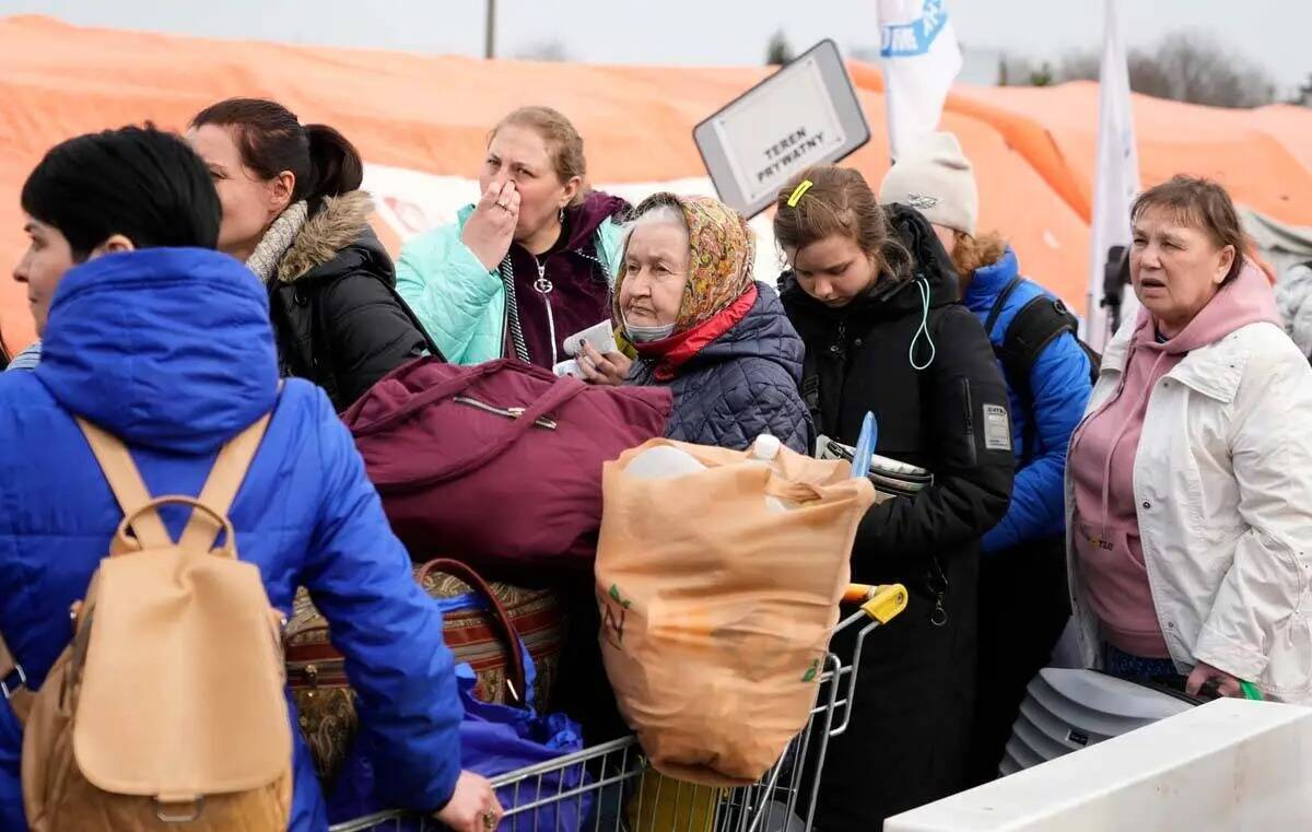 Refugiados hacen fila con sus pertenencias tras huir de la guerra de la vecina Ucrania en el pa ...