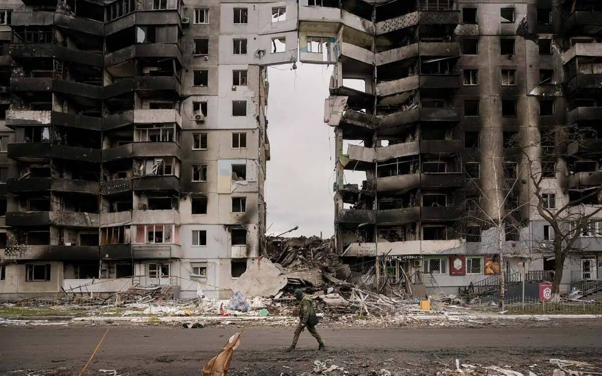 Un militar ucraniano camina junto a un edificio de apartamentos destruido en Borodyanka, Ucrani ...