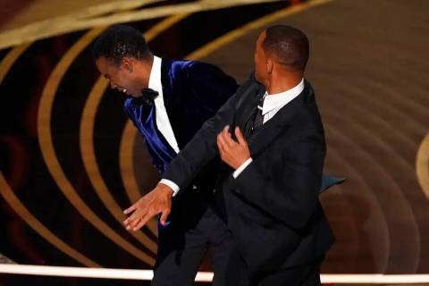 Will Smith, a la derecha, golpea al presentador Chris Rock en el escenario mientras presenta el ...