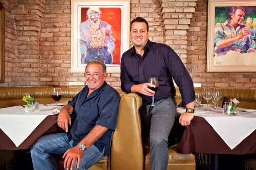 Freddie, a la izquierda, y Evan Glusman se relajan en su restaurante, Piero's Italian Cuisine, ...