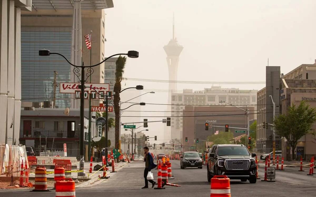 Un peatón cruza Las Vegas Boulevard en el centro de la ciudad mientras los vientos traen una t ...