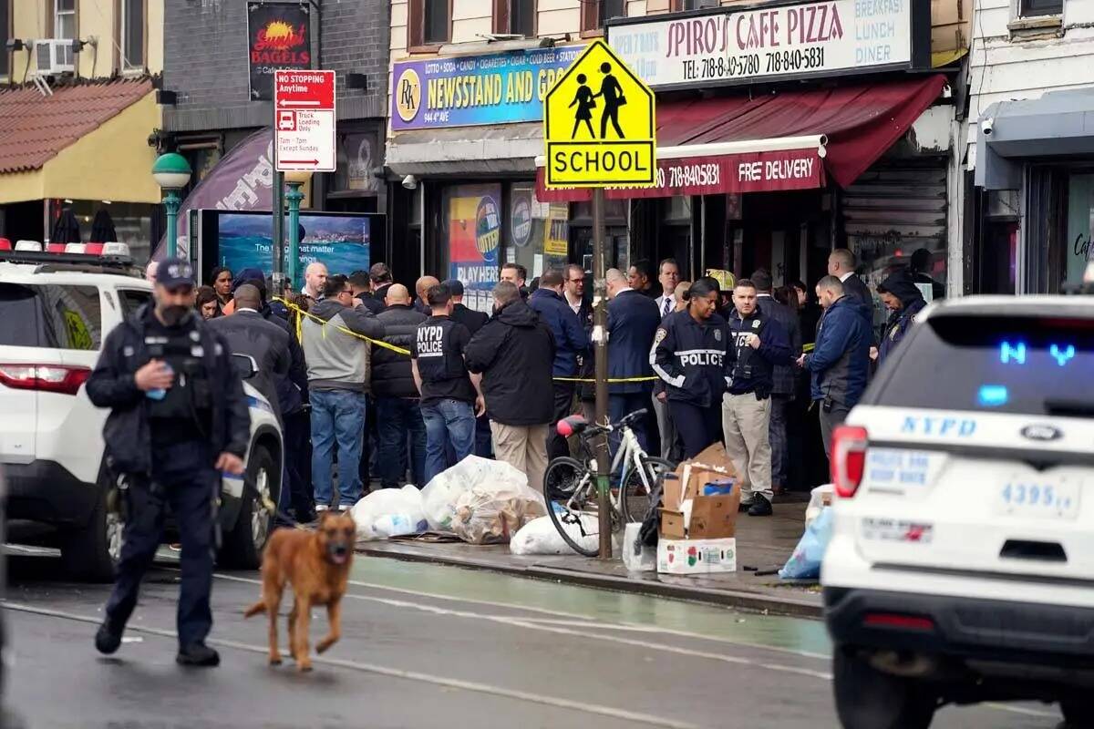 Agentes del Departamento de Policía de la Ciudad de Nueva York se reúnen en la entrada de una ...