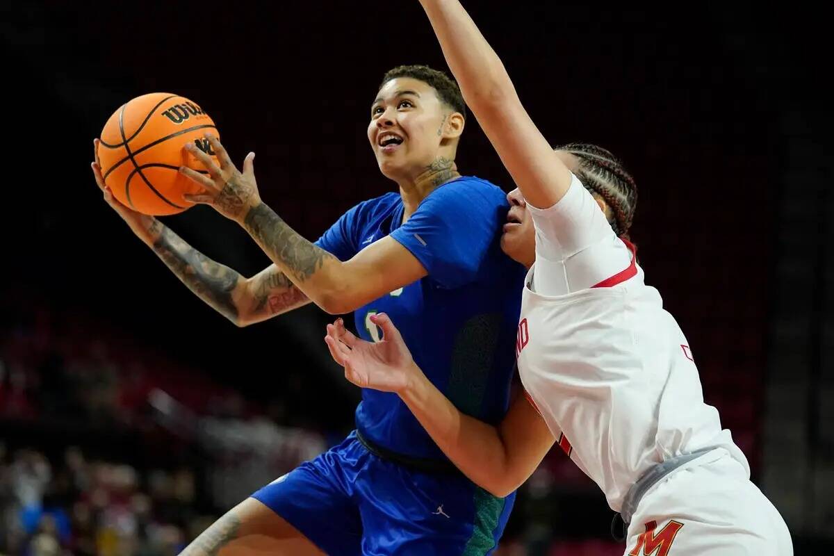 El escolta de Florida Gulf Coast, Kierstan Bell, a la izquierda, salta a canasta contra la aler ...