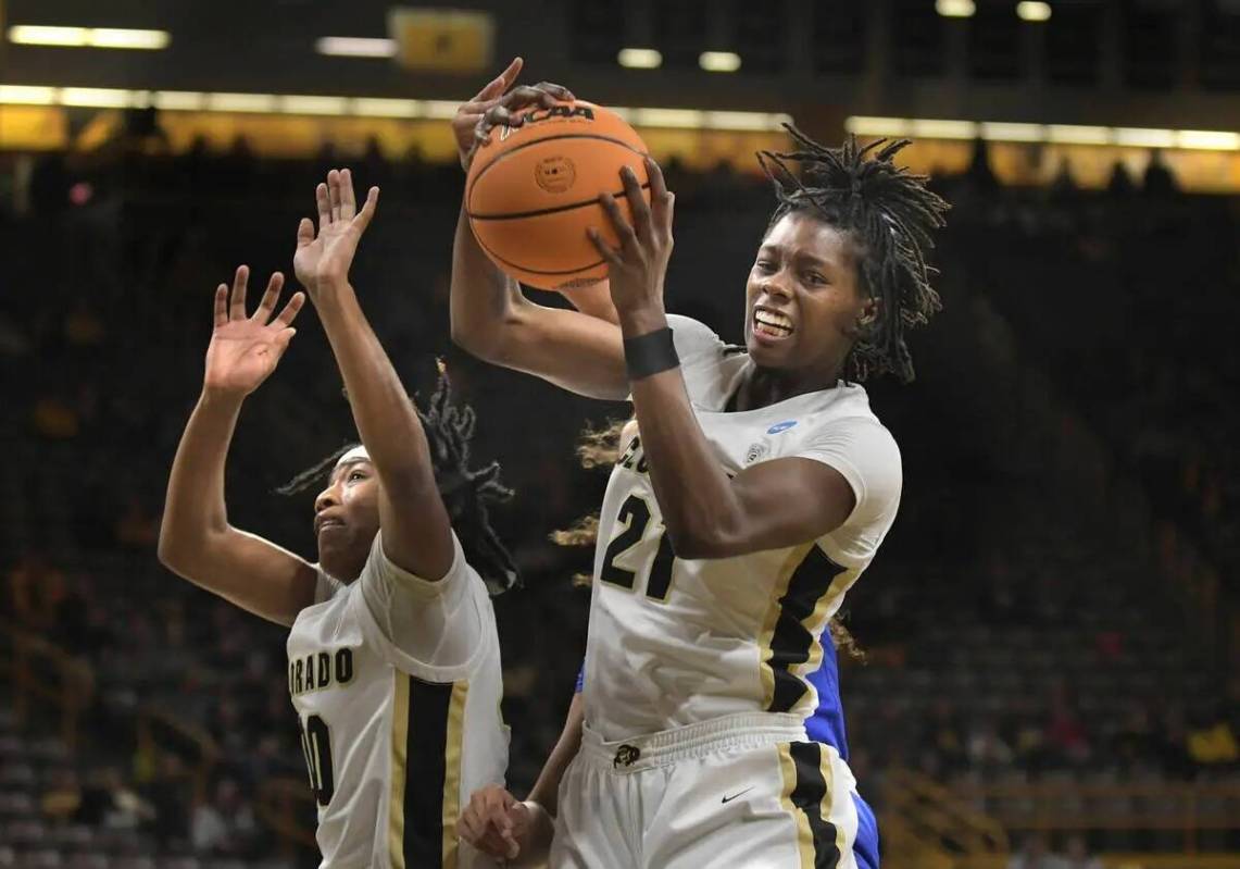 La alera de Colorado Mya Hollingshed (21) toma un rebote con su compañera Jaylyn Sherrod (00) ...