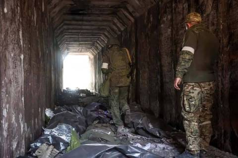 Milicianos de la República Popular de Donetsk observan los cuerpos de los soldados ucranianos ...