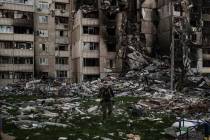 Un militar ucraniano camina entre los escombros de un edificio fuertemente dañado por los múl ...
