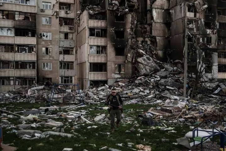 Un militar ucraniano camina entre los escombros de un edificio fuertemente dañado por los múl ...
