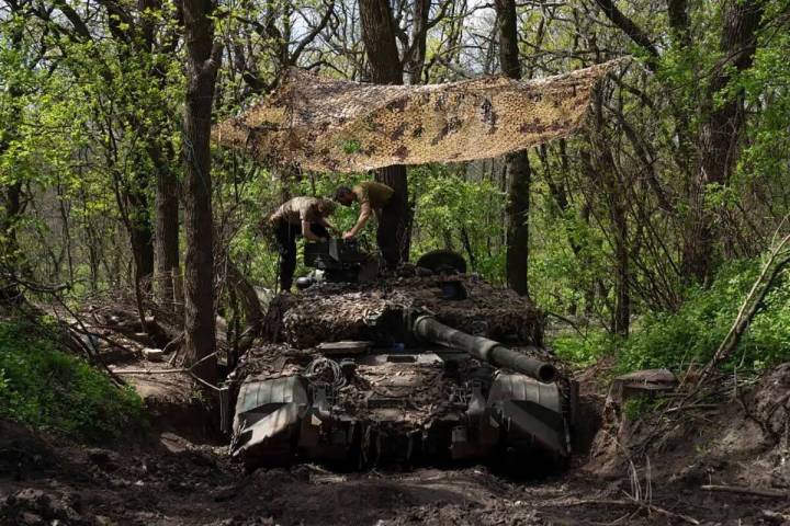 Militares ucranianos instalan una ametralladora en el tanque durante los trabajos de reparació ...