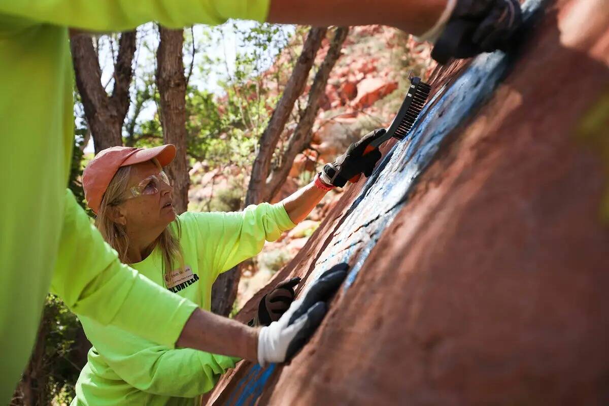 La voluntaria Beth Schuck trabaja para eliminar grafitis en el sendero de Ash Springs en Red Ro ...