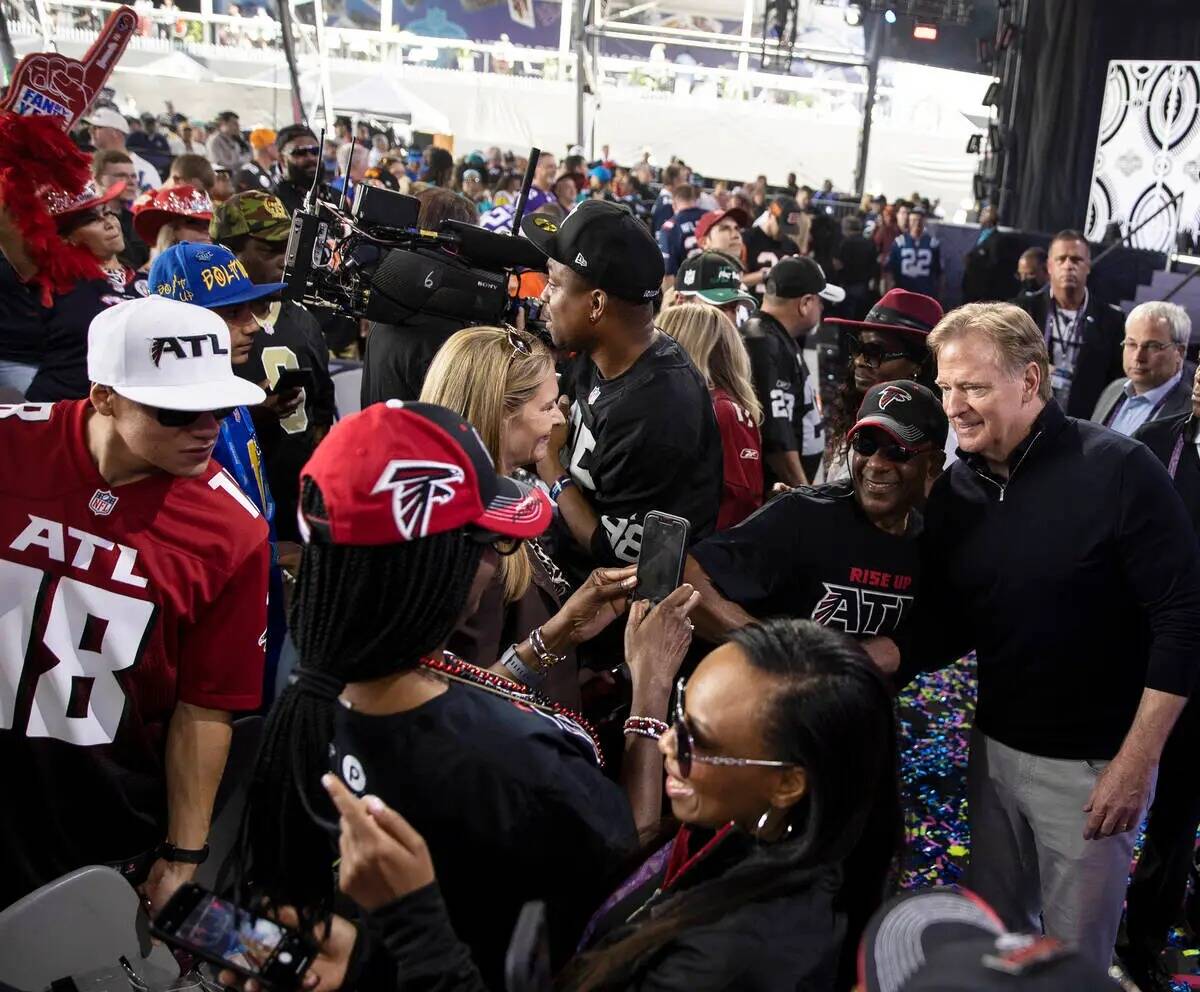El comisionado de la NFL, Roger Goodell, a la derecha, socializa con los fans durante el tercer ...