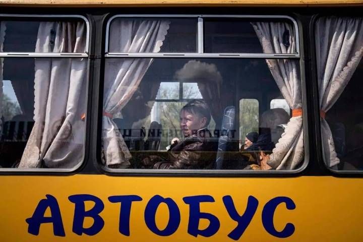 Unas mujeres esperan en un autobús en un centro para personas desplazadas en Zaporizhzhia, Ucr ...