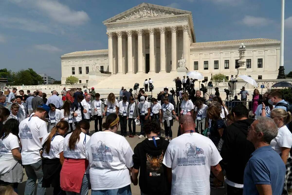 Personas rezan frente al Tribunal Supremo de Estados Unidos el martes 3 de mayo de 2022 en Wash ...