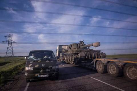 Un camión transporta una plataforma con un vehículo ucraniano de artillería autopropulsada e ...