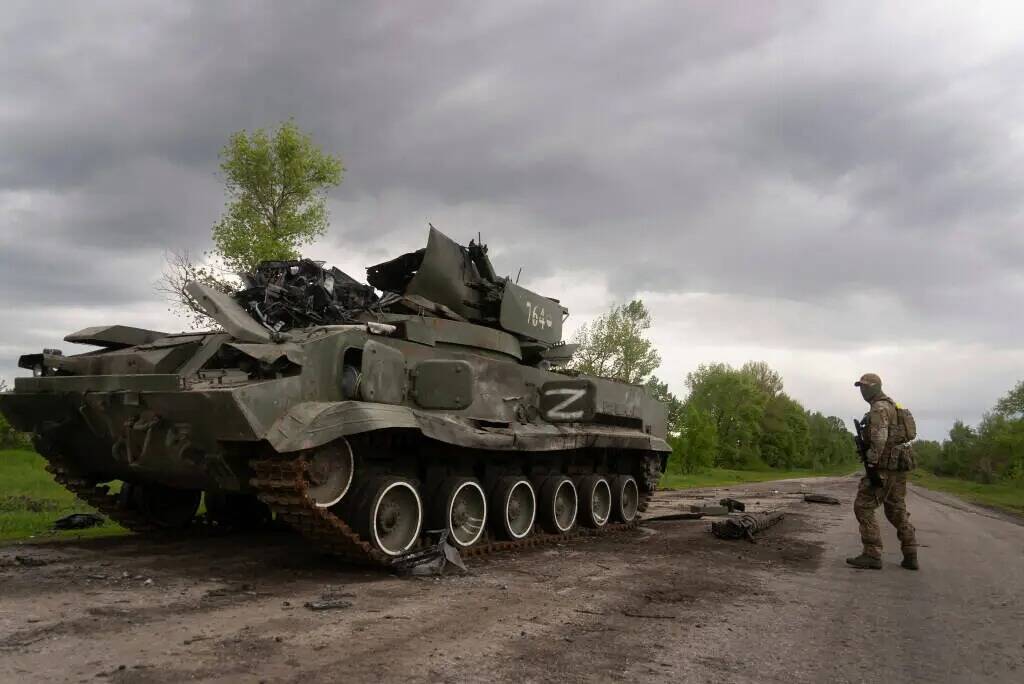 Un militar ucraniano pasa por delante de un vehículo blindado ruso volado cerca de Kutuzivka, ...