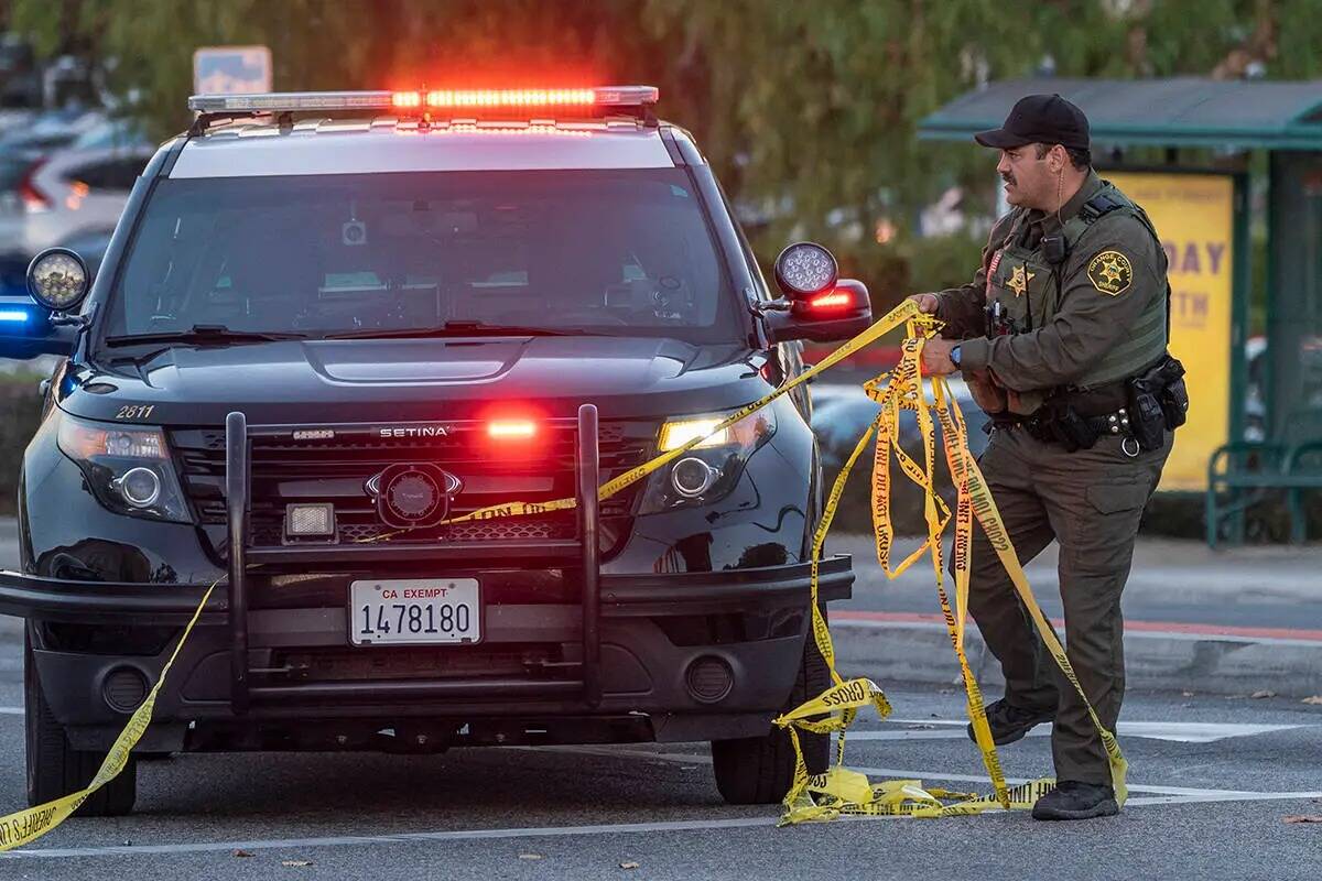 Un ayudante del alguacil del Condado Orange retira la cinta amarilla de un vehículo frente a l ...