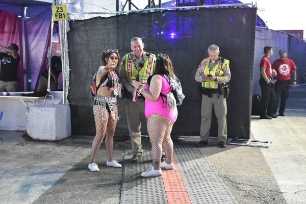 Un oficial de LMVPD conversa con dos asistentes durante el segundo día de EDC Las Vegas. Sába ...