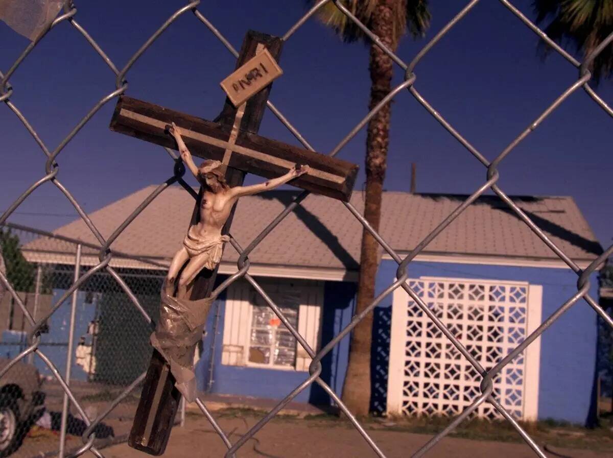 Un crucifijo cuelga de una valla frente a la casa donde Timmy "T.J." Weber mató a Kim Gautier ...