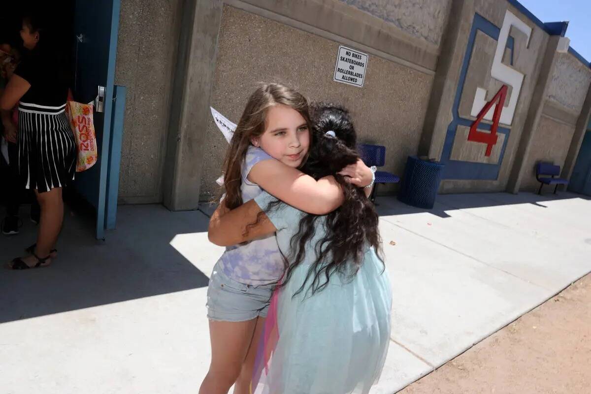 La alumna de tercer grado Shea Shultzman, de ocho años, a la izquierda, abraza a Perla Contere ...