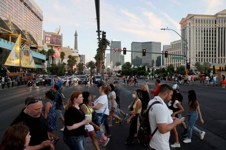 Una multitud cruza el Strip entre el Linq Promenade y el Caesars Palace en Las Vegas el viernes ...