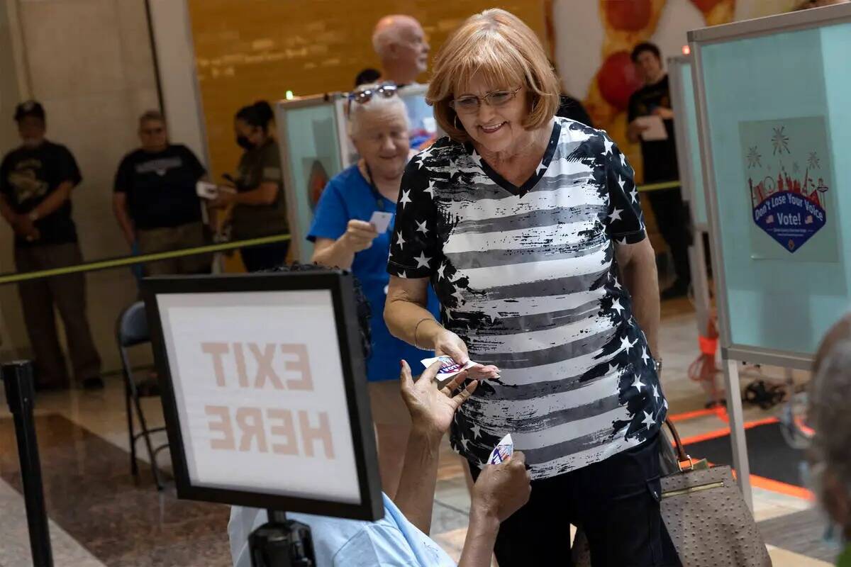Cheryl Hartle, de Las Vegas, recibe una calcomanía después de emitir su voto durante la votac ...