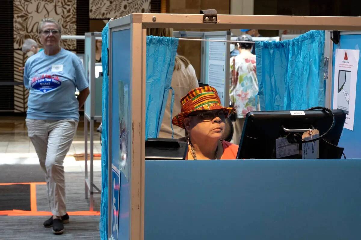 Karen L. Ballard, a la derecha, de Las Vegas, emite su voto durante la votación anticipada en ...