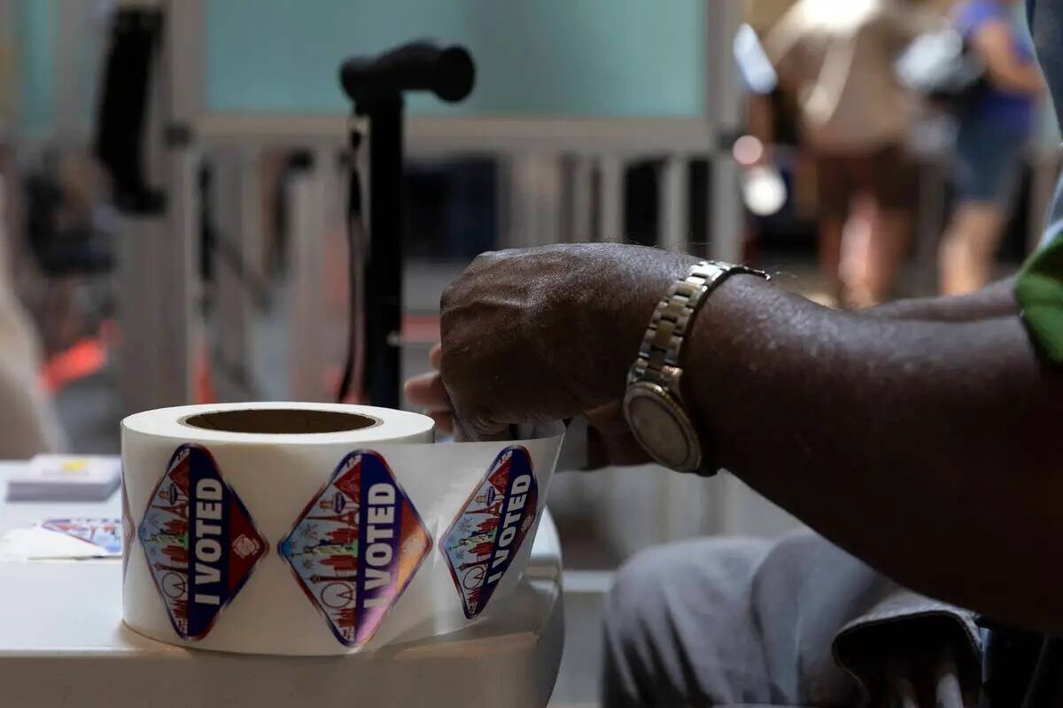 Un trabajador electoral prepara calcomanías para los votantes anticipados en el centro comerci ...